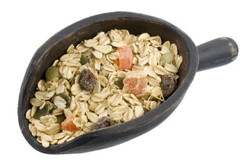 muesli cereal with papaya fruit, pepitas and raisins on a scoop