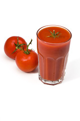 Studio shot of glass with fresh tomato juice  and two tomatoes