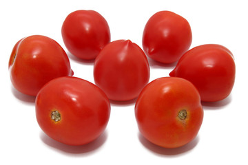 Seven red fresh tomatoes on a white background
