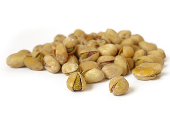 Heap of salty pistachios isolated. Soft focus