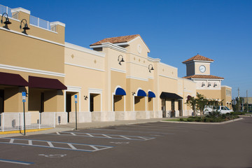 upscale pastel strip mall with awnings and corner clock tower