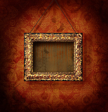 Gilded picture frame on antique wallpaper background