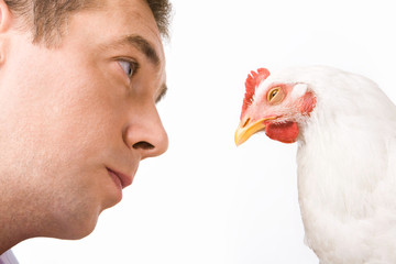 Face of man looking at chicken with calm expression on it