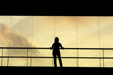 Fototapeta na wymiar woman in the modern buildind at sunset