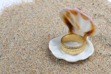 Gold wedding ring in a seashell