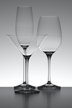 Three glasses isolated over a gray backlit background.