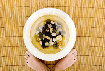 Man's feet in bowl of water and rocks