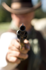 Cowboy aiming gun, focus only on gunpoint