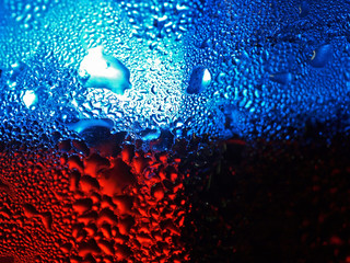 Blue And Red Waterdrops Hanging On Irregular Glass