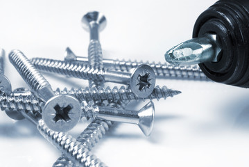 A group of phillip headed screws with a mechanical screwdriver