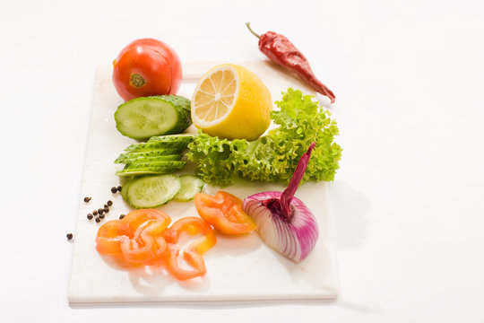 Vegetable mix: lettuce, onion, lemon, cucumber on the board