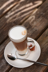 Coffee Latte on old wood table with gobo light on back