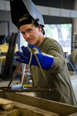 Fototapeta na wymiar Metal worker in a factory wearing his welding visor.
