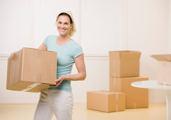 Woman moving cardboard boxes in new home