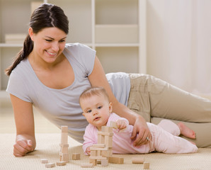 mother and baby playing with blocks on livingroom floor