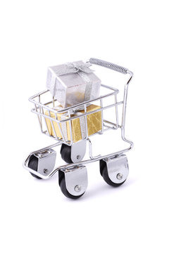 Gift boxes in a mini shopping cart on white background