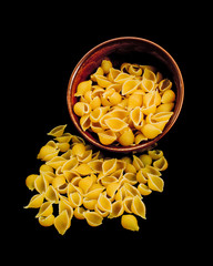 Shell Pasta in ceramic bowl isolated over black background