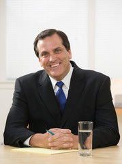 Confident businessman with pen and legal pad