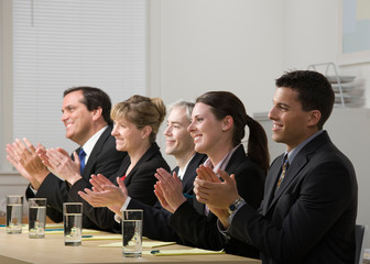 Panel of co-workers applauding