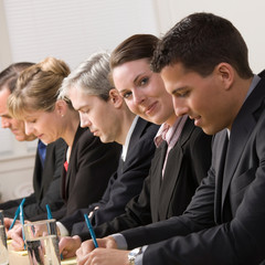 Happy businesswoman on panel of co-workers