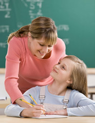 Teacher explaining homework to student in school classroom