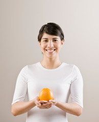 Hungry woman holding fresh whole orange