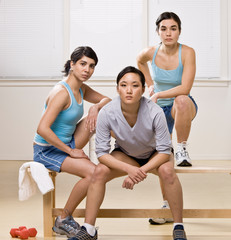 Obraz premium Friends in sportswear sitting on bench in health club
