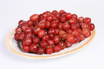 a plate of grapes isolated on white background.