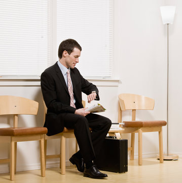 Businessman anxiously waiting for appointment in waiting area