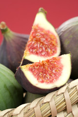 basket of fresh figs on red background - food and drink