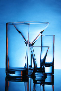 Still-life with empty glasses over blue background