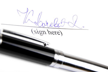 Signature and pen on white background