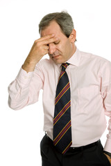 Businessman in a suit gestures with a headache