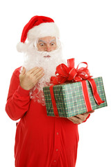 Santa Claus in his pajamas, surprised by a Christmas gift.