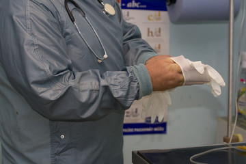 Doctor, putting on medical gloves