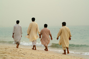 groupe d'hommes sur la plage en costume pakistanais