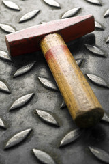 a red head hammer on a metal surface (shallow depth of field)