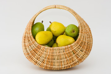 yellow and green pears in a row wicker basket