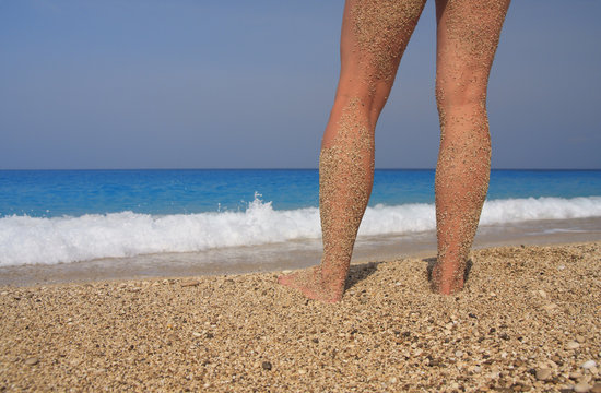 Someone is taking a sun-bath near the foamed waves.