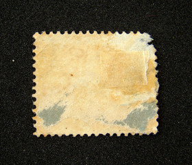 Blank and worn postage stamp on black background