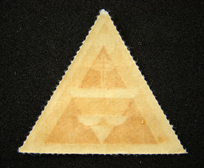 Blank triangular postage stamp on black background
