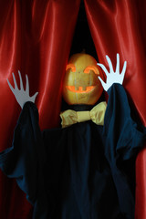 Halloween scarecrow on background with red drop-curtain