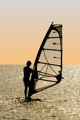 Naklejka premium Silhouette of a windsurfer on waves of a gulf