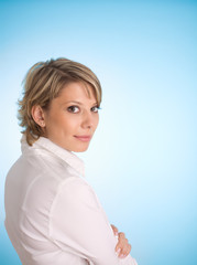 Obraz premium Clever businesswoman in half turn over blue background