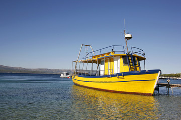 Fototapeta premium Yellow diving boat in harbour on Brac island in Croatia