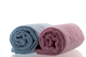 Obraz na płótnie Canvas Pink and light blue rolled up towels
