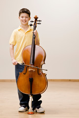 Confident musician standing with cello © AVAVA