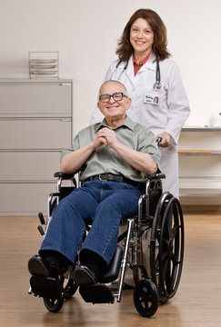 Doctor pushing disabled patient in wheel chair