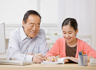 Student listening to grandfather explain homework