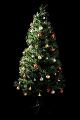 Decorated Christmas-tree on black background .